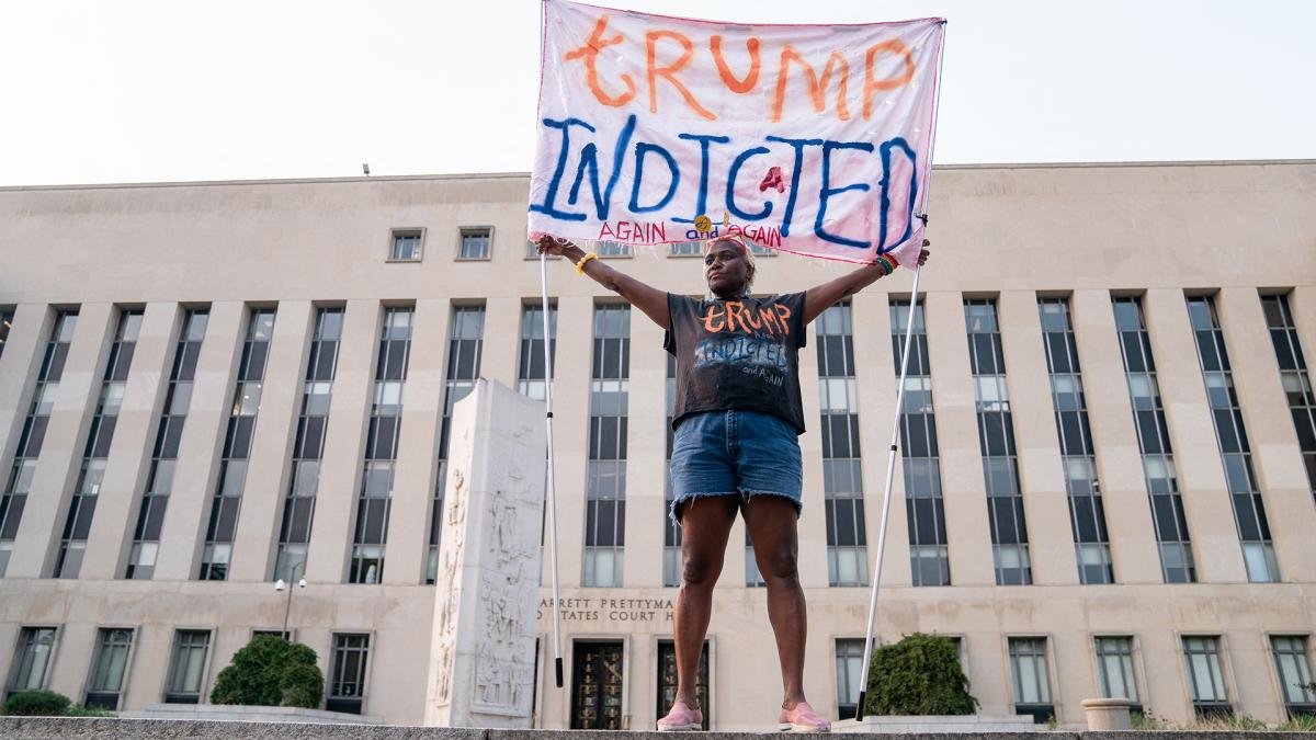 Con un cartel Trump acusado una manifestante celebra la imputacin del ex mandatario Foto AFP